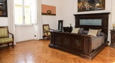a bedroom with a large bed and a wooden floor at B&B Villa Musa in Rome