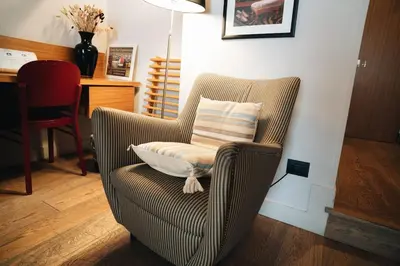 a chair with a pillow in a living room at DownTown Boutique House - CA Domus Collection in Rome