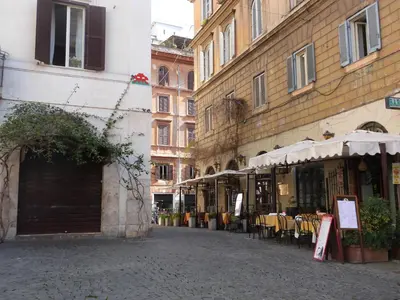an empty street with tables and chairs and buildings at Colosseo Homerents 2 in Rome