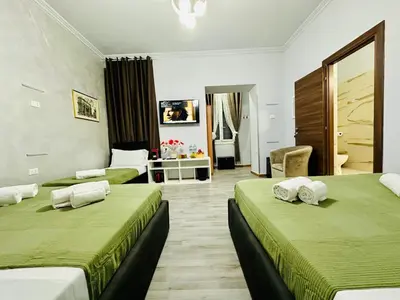 a hotel room with two beds with green sheets at Termini luxury home in Rome
