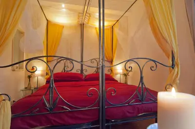 a bedroom with a red bed with a candle at Light of Rome in Rome