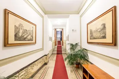 a bedroom with white walls and a bed and a chair at Al Centro Storico Roma Suite in Rome
