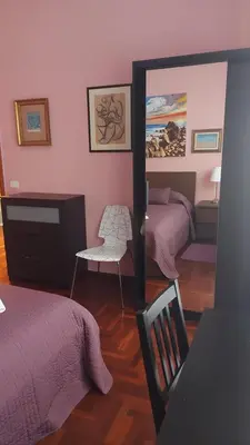 a bedroom with two beds and a mirror at Appartamento Isabella in Rome