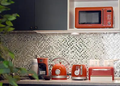 a kitchen counter with an orange toaster and a microwave at B&B Ventisei Scalini A Trastevere in Rome