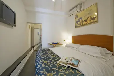 a bedroom with a large bed and a tv at B&B Ventisei Scalini A Trastevere in Rome