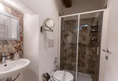 a bathroom with a shower and a toilet and a sink at B&B Ventisei Scalini A Trastevere in Rome
