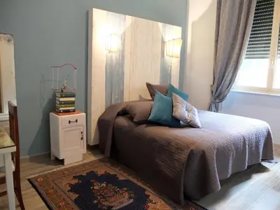a bedroom with a bed and a table and a window at Dimora Al 36 in Rome