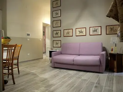 a living room with a purple couch and a table at Dimora Al 36 in Rome