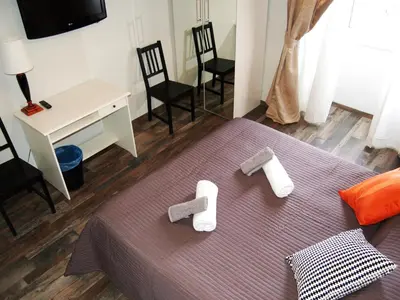 a bedroom with a bed with two feet and two chairs at Luiza Vatican House in Rome