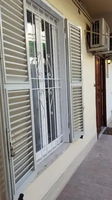 a window with blinds on the side of a house at Luiza Vatican House in Rome