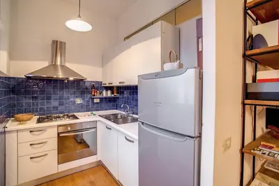 a kitchen with a white refrigerator and a sink at Ponte Testaccio Loft in Rome