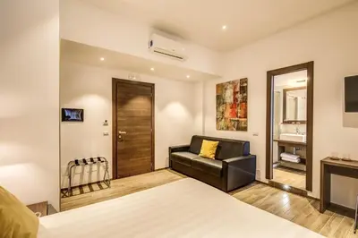 a bedroom with a bed and a chair and a television at House Garden in Rome