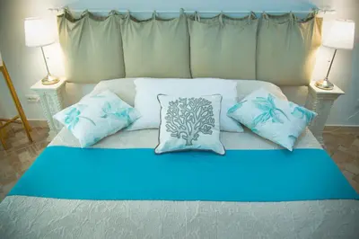 a bed with blue and white pillows on it at Casa Alberone in Rome