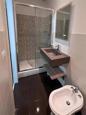 a bathroom with a sink and a shower and a toilet at The B Place Cola in Rome