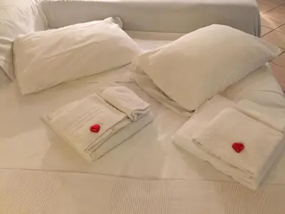 a white bed with white pillows and red buttons at SUITE 14 - Appartamento delizioso in ROMA Centro- 200 mt da METRO B in Rome