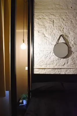 a mirror hanging on a brick wall with a lamp at Bibi e Romeo's Home in Rome
