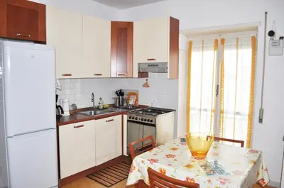 a kitchen with white cabinets and a table with a bowl on it at Piazza Meucci in Rome