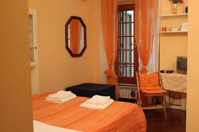 a room with a bed with a mirror and a chair at B&B A Casa Di Nancy in Rome