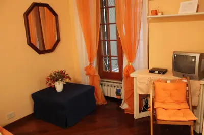 a living room with a table and a tv and a window at B&B A Casa Di Nancy in Rome