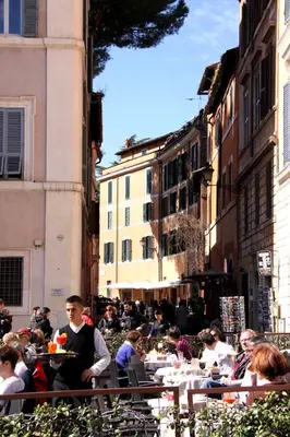 a group of people sitting at tables in a city at Domus31 - Luxury House in Trastevere in Rome