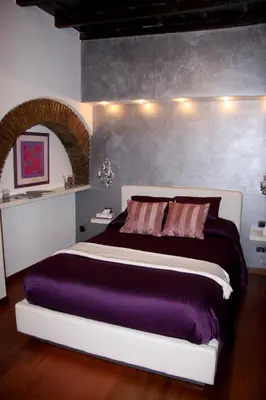 a bedroom with a purple bed with lights on the wall at Domus31 - Luxury House in Trastevere in Rome