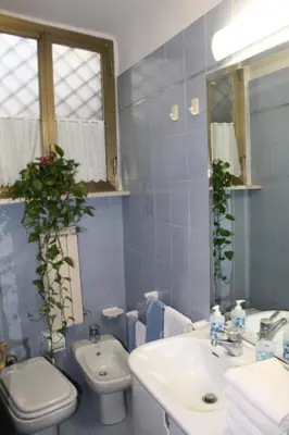 a blue bathroom with a sink and a toilet at Oltre le Mura in Rome