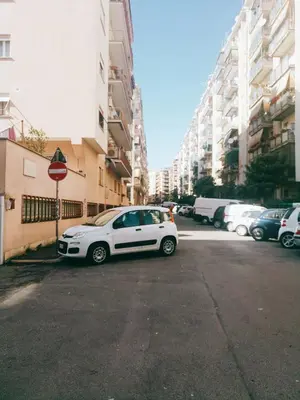 a white car parked in a parking lot next to buildings at Green Line in Rome