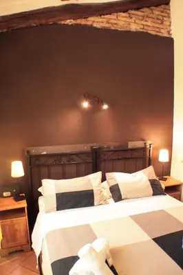 a bedroom with two beds and a brick wall at Sixtythree guesthouse in Rome