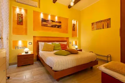a bedroom with a bed with yellow walls at Domus Clodio in Rome
