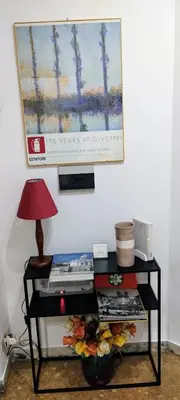 a table with a lamp and a picture on the wall at Trionfal Apartment in Rome
