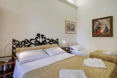 a bedroom with two beds and a painting on the wall at At Rome St. Peter's in Rome