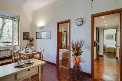 a living room with a table and a clock on the wall at At Rome St. Peter's in Rome
