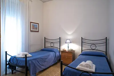 two beds in a bedroom with blue sheets and towels at Giornate Romane in Rome