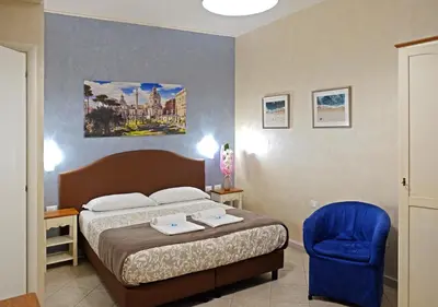 a bedroom with a bed and a blue chair at Re Monti in Rome