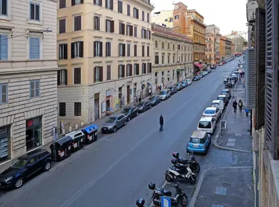 a city street with cars and motorcycles parked on the street at Re Monti in Rome