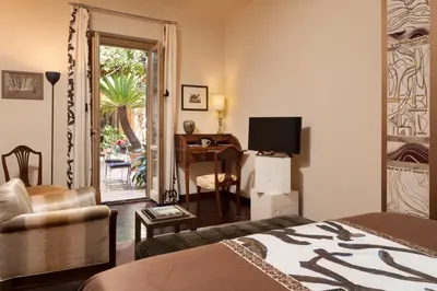 a bedroom with a bed and a desk with a television at Buonanotte Garibaldi in Rome