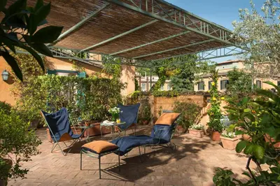 a patio with chairs and a table in a yard at Buonanotte Garibaldi in Rome