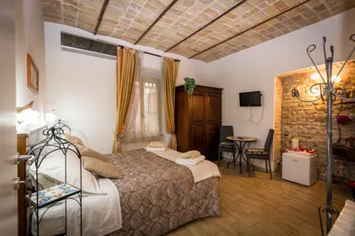 a bedroom with a bed and a table in a room at All'Ombra Del Cupolone Guest House in Rome
