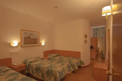 a hotel room with two beds and a hallway at Hotel Tirreno in Rome