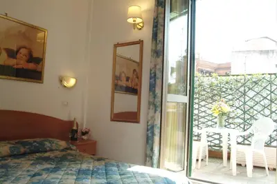 a bedroom with a bed and a sliding glass door at Hotel Tirreno in Rome