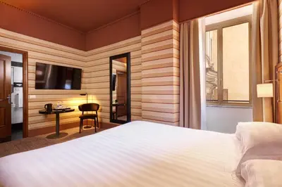 a hotel room with a large bed and a desk at Hotel Mascagni in Rome
