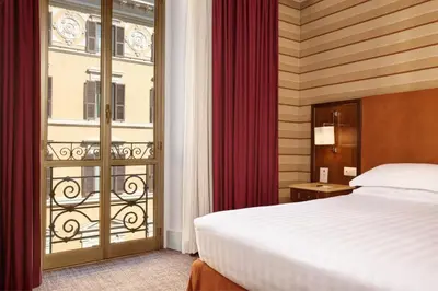 a hotel room with a bed and a balcony at Hotel Mascagni in Rome