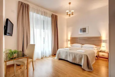 a bedroom with a bed and a desk and a television at Hotel King in Rome