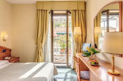 a hotel room with a bed and a desk and a window at Hotel King in Rome