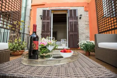a bottle of wine and a bowl of strawberries on a table at Pettinary Village B&B in Rome