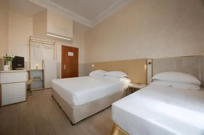 a hotel room with two beds and a television at Hotel Palladium Palace in Rome