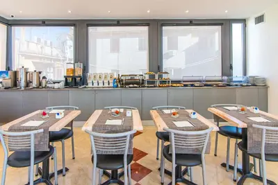 a bar with stools and plates of food on a counter at Hotel Aphrodite in Rome