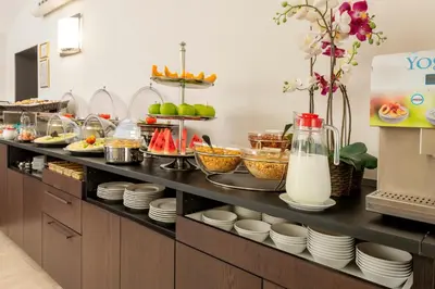 a kitchen with a buffet with plates and milk at Hotel Des Artistes Roma in Rome