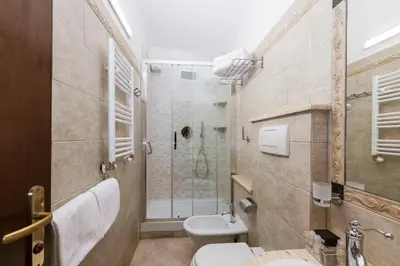 a bathroom with a shower and a toilet and a sink at Hotel Des Artistes Roma in Rome