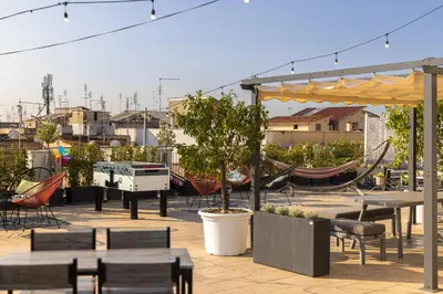 a patio with tables and chairs and a hammock at Generator Rome in Rome